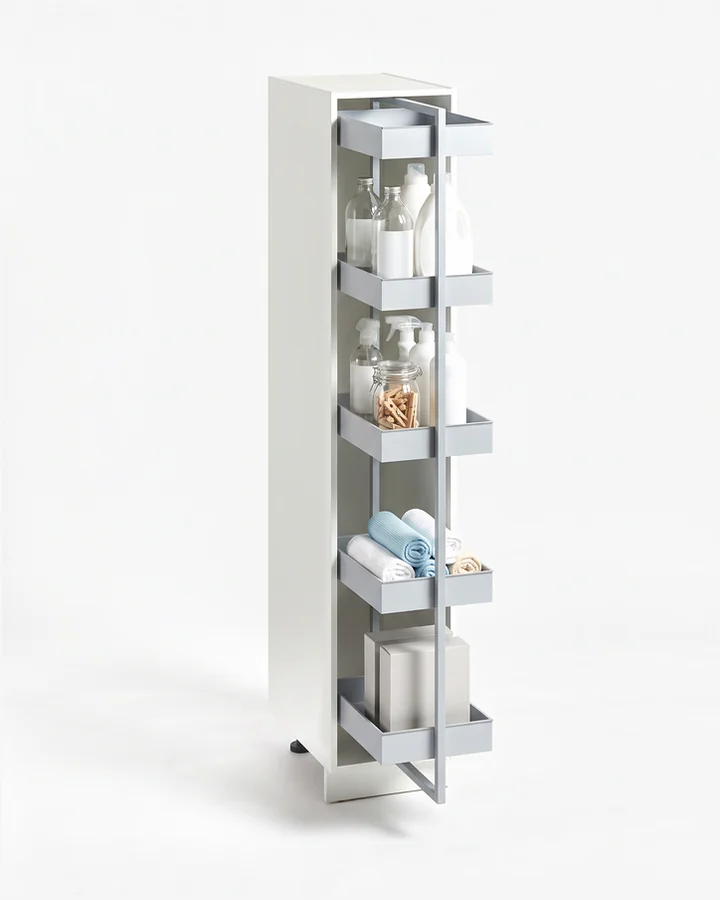 Witte kast van 40 cm zonder deur, met een uittrekkast met vijf korven, half naar voren getrokken, vol flessen, sprays en wasknijpers.