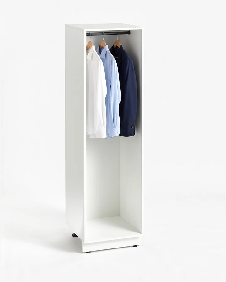 Witte kast van 60 cm zonder deur, met een zwarte roede bovenin. Aan de hangers twee overhemden en een colbert.