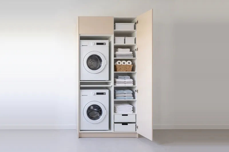 Impressie: wasmachinekast met een kast, 123,7 cm breed en 250 cm hoog, fronten in zandkleur, met deuren open.