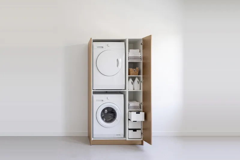 Impressie: wasmachinekast met een kast, 103,7 cm breed en 210 cm hoog, fronten in brons, met deuren open.