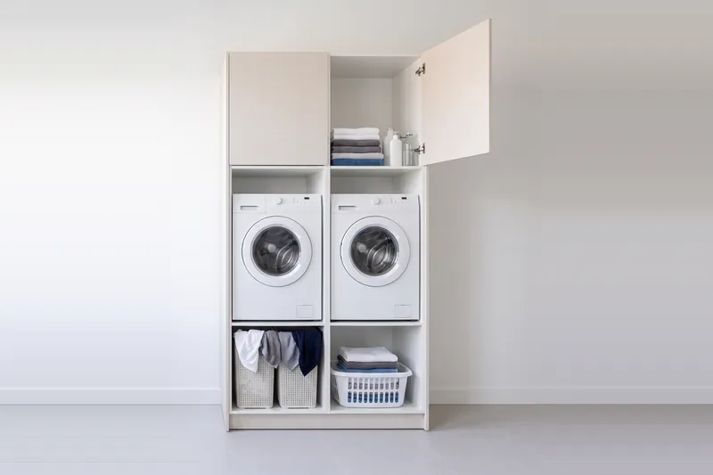 Impressie: twee wasmachinekasten, 133,7 cm breed en 250 cm hoog, fronten in structuur, met deuren open.