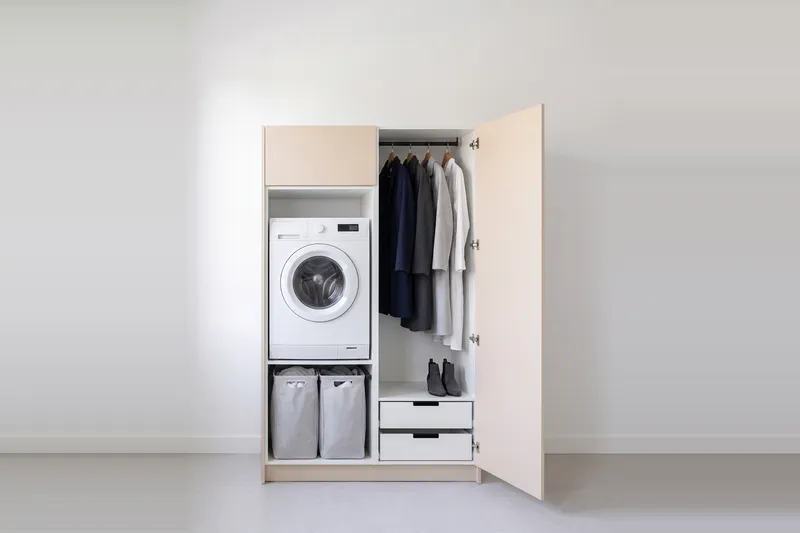 Impressie: wasmachinekast met een kast, 128,7 cm breed en 210 cm hoog, fronten in zandkleur, met deuren open.