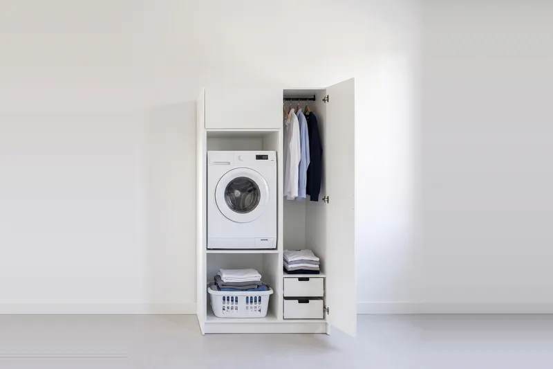 Impressie: wasmachinekast met een kast, 108,7 cm breed en 210 cm hoog, fronten in wit, met deuren open.