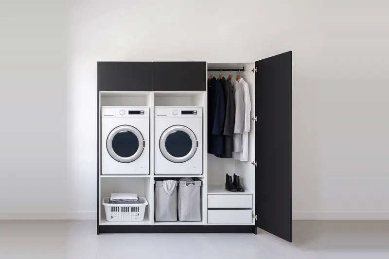 Impressie: twee wasmachinekasten met een kast, 193,8 cm breed en 210 cm hoog, fronten in zwart, met deuren open.