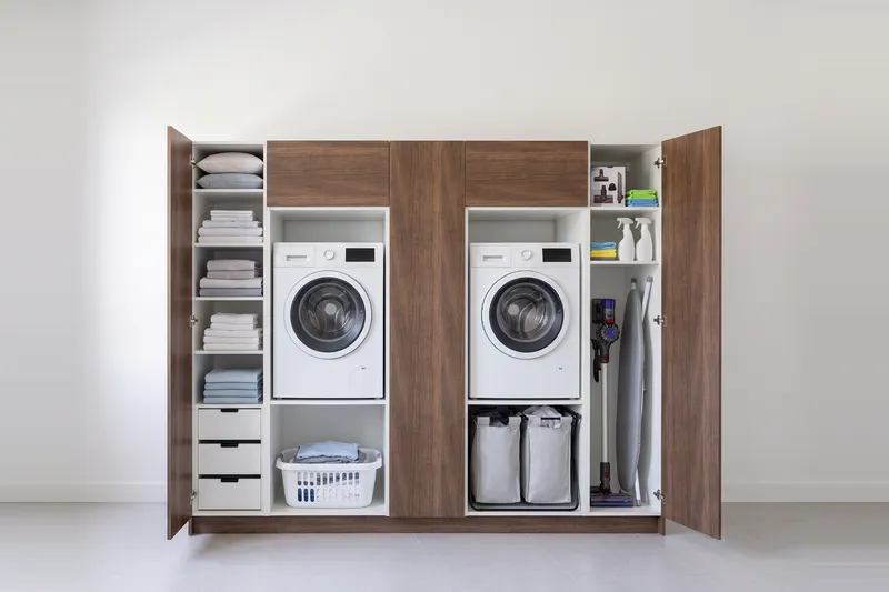 Impressie: twee wasmachinekasten met drie kasten, 254 cm breed en 210 cm hoog, fronten in walnoot, met deuren open.