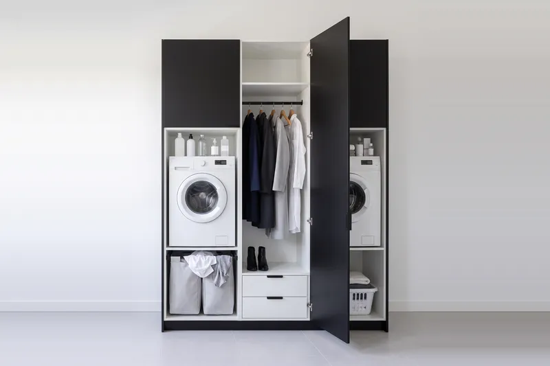 Impressie: twee wasmachinekasten met een kast, 193,8 cm breed en 250 cm hoog, fronten in zwart, met deuren open.