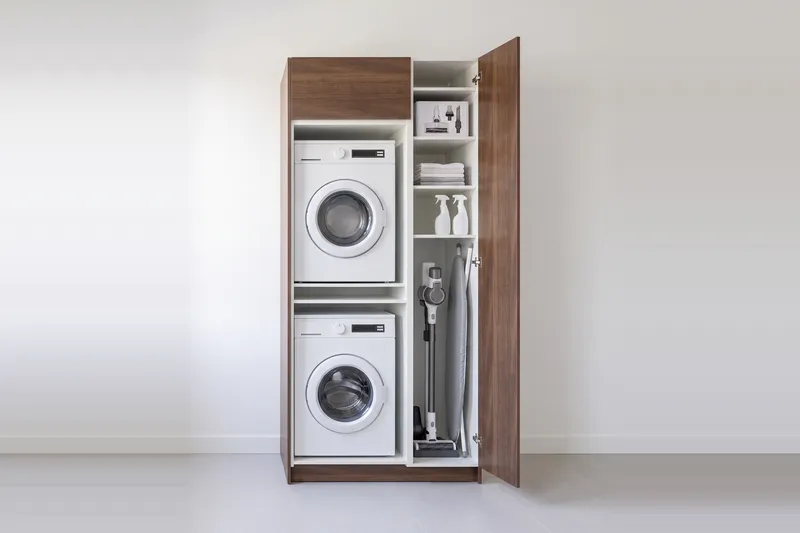 Impressie: wasmachinekast met een kast, 113,7 cm breed en 250 cm hoog, fronten in walnoot, met deuren open.