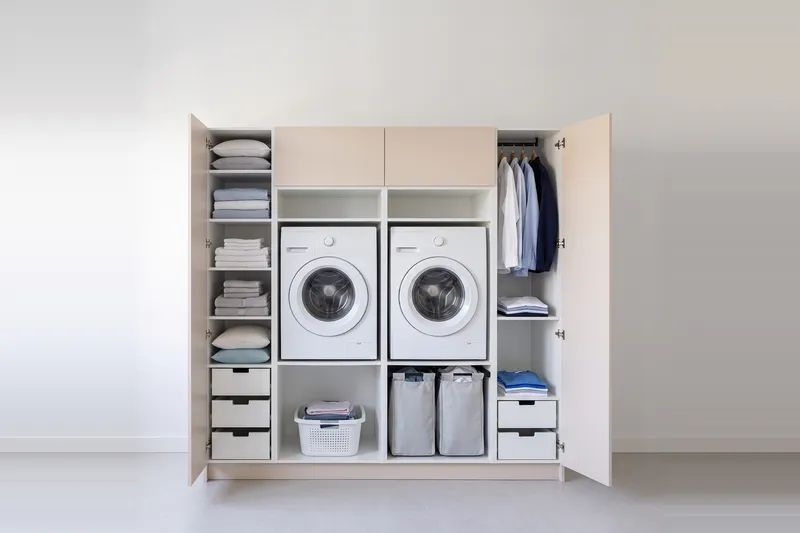 Impressie: twee wasmachinekasten met twee kasten, 213,9 cm breed en 210 cm hoog, fronten in zandkleur, met deuren open.