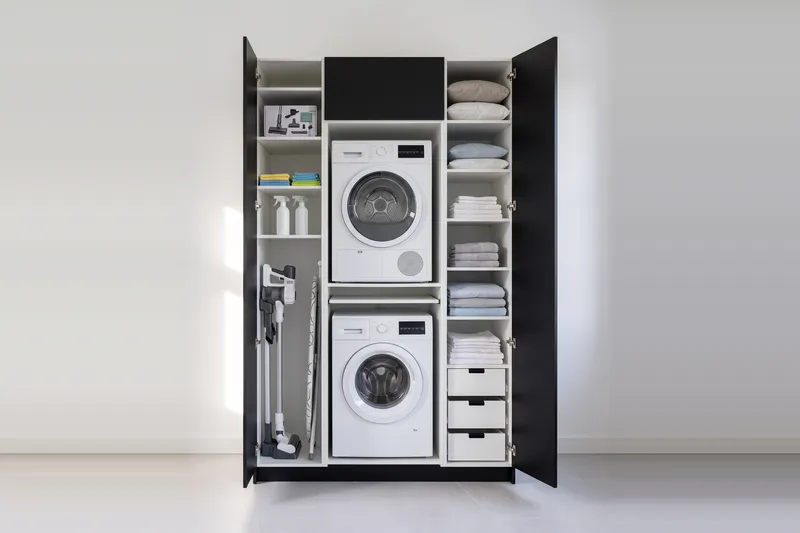 Impressie: wasmachinekast met twee kasten, 153,8 cm breed en 250 cm hoog, fronten in zwart, met deuren open.