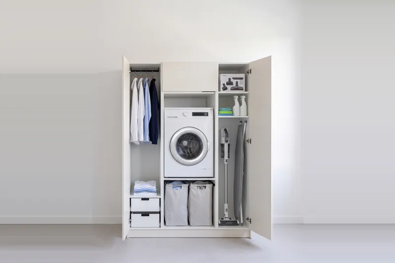 Impressie: wasmachinekast met twee kasten, 148,8 cm breed en 210 cm hoog, fronten in wit, met deuren open.